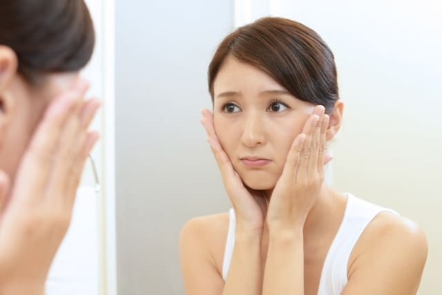 両手を頬にあてている写真